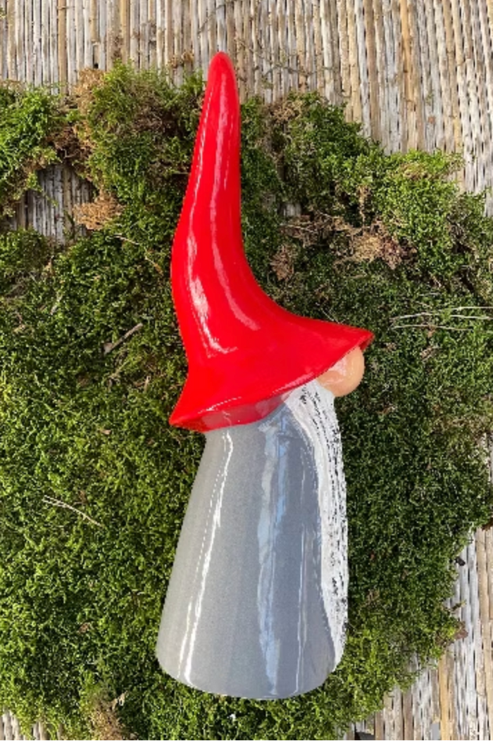 Decorative gnome with a red hat on a green moss background from Goose and Company