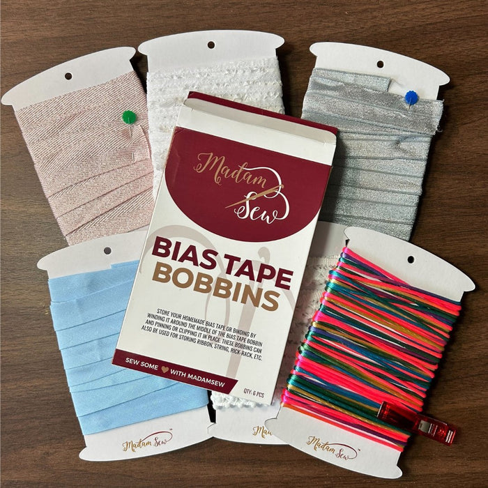 Six bobbins in one box with trims on it, bias tape, strings,...