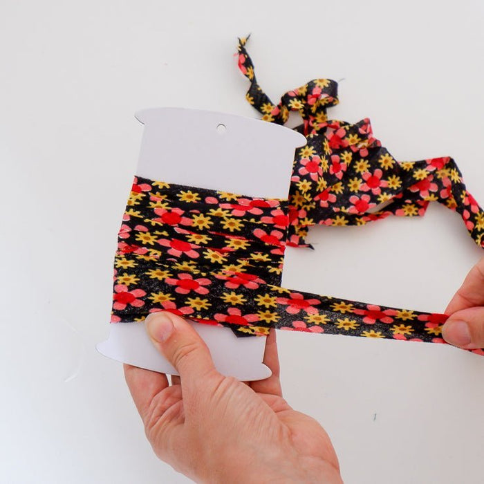Women winding homemade bias tape on a bias tape bobbin for storage