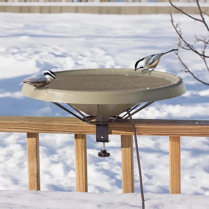 Deck Mount Heated Bird Bath clamped to a snowy deck rail, with a red-breasted nuthatch and black-capped chickadee perched on its rim.