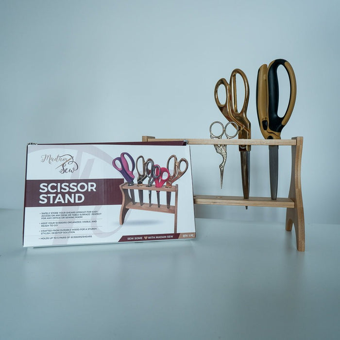 the bow of the scissor stand by Madam Sew and the scissor stand behind it holding 3 pairs of sewing scissors