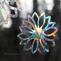 Close-up of Flower Window Gems, Set of 9, prismatic decals on a window designed to prevent bird strikes and add elegance.