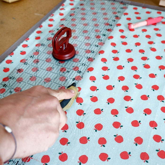 Quilting ruler with a ruler grip used to cut fabric with a rotary cutter